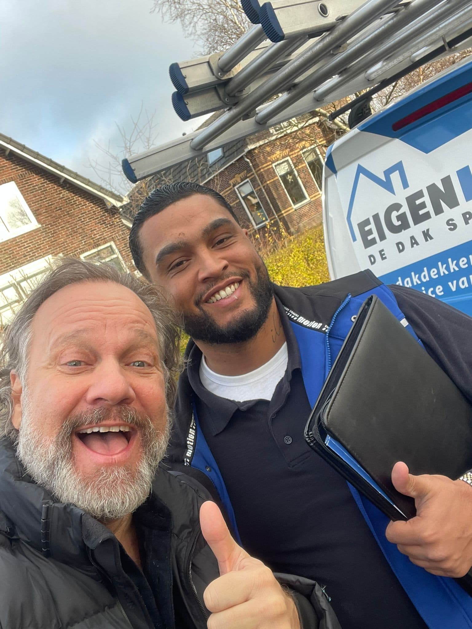 Tevreden klant en dakdekker poseren lachend voor Eigen Dak servicebus